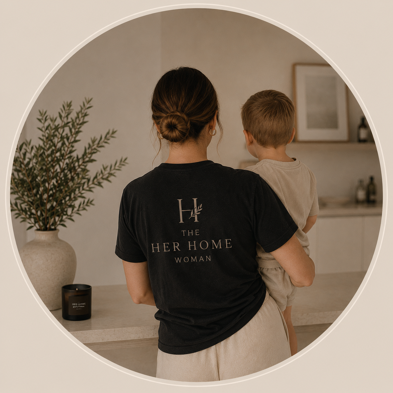 The owner of Her Home Collective wearing The Her Home Woman tee, holding her child